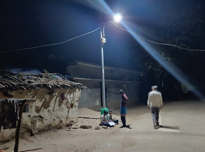 Children doing homework under a streetlight