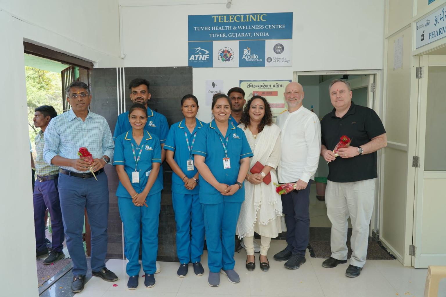 Ariel Armony and Tom O'Toole standing with Apollo staff at the THWC in Gujarat, India