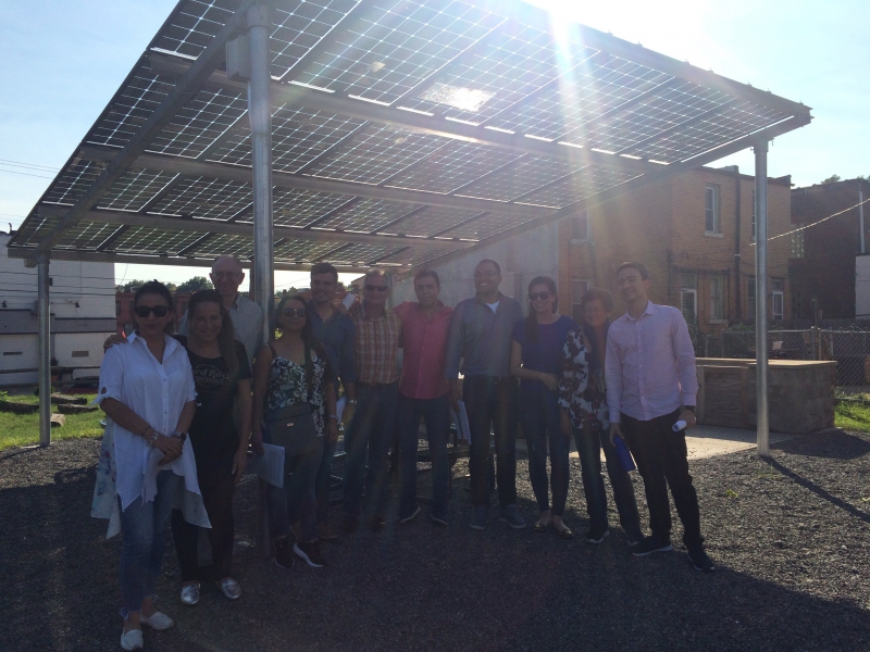 Group photo in front of solar panel pavilion in Homewood