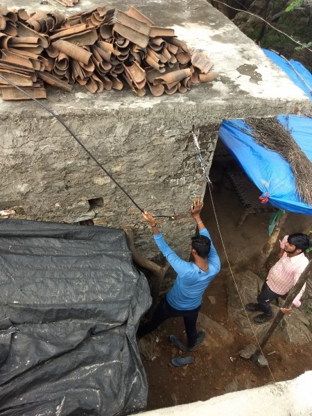 Worker moving roof tiles in Tuvar Village